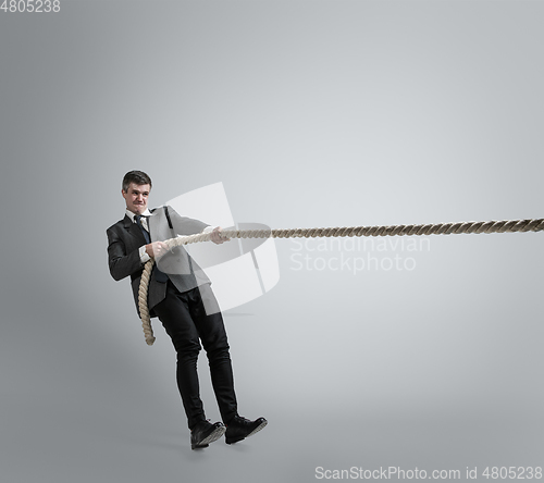 Image of Caucasian man in office clothes training isolated on grey studio background