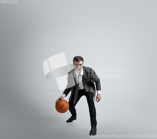 Image of Caucasian man in office clothes training isolated on grey studio background