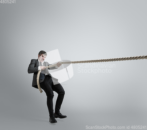 Image of Caucasian man in office clothes training isolated on grey studio background