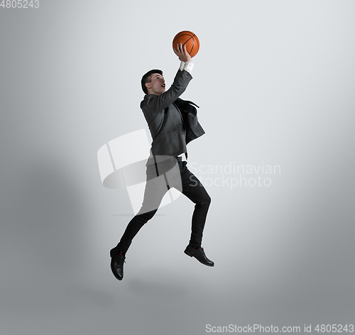 Image of Caucasian man in office clothes training isolated on grey studio background