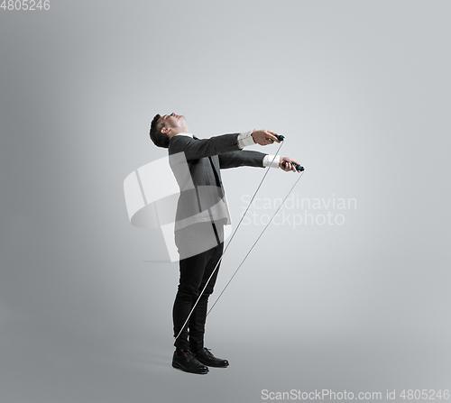 Image of Caucasian man in office clothes training isolated on grey studio background