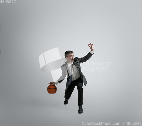 Image of Caucasian man in office clothes training isolated on grey studio background