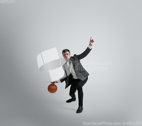 Image of Caucasian man in office clothes training isolated on grey studio background