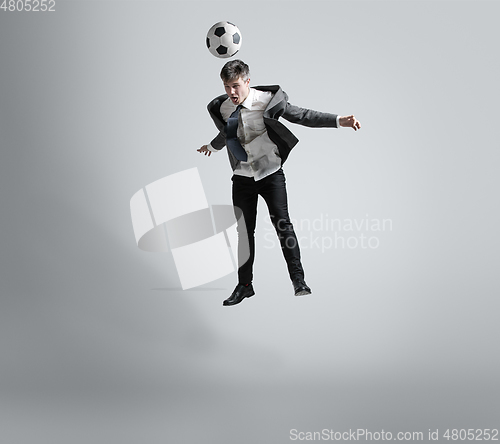 Image of Caucasian man in office clothes training isolated on grey studio background