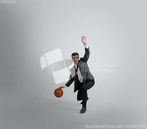 Image of Caucasian man in office clothes training isolated on grey studio background