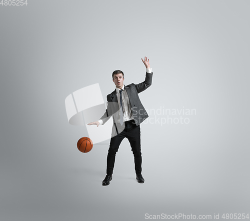 Image of Caucasian man in office clothes training isolated on grey studio background