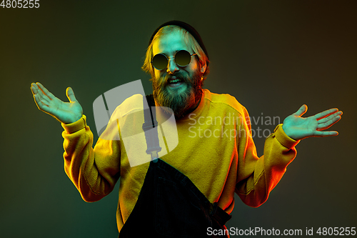 Image of Caucasian man\'s portrait isolated on gradient studio background in neon light