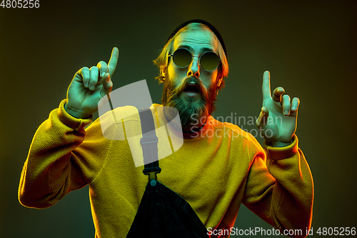 Image of Caucasian man\'s portrait isolated on gradient studio background in neon light
