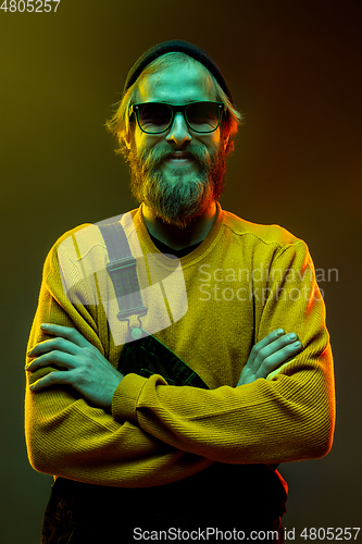 Image of Caucasian man\'s portrait isolated on gradient studio background in neon light