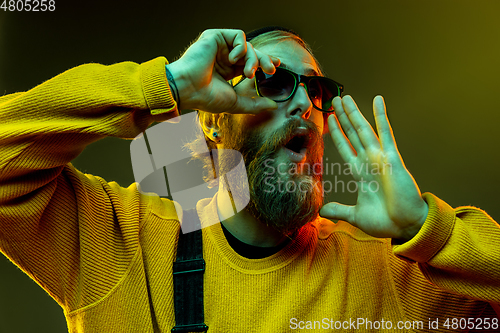 Image of Caucasian man\'s portrait isolated on gradient studio background in neon light