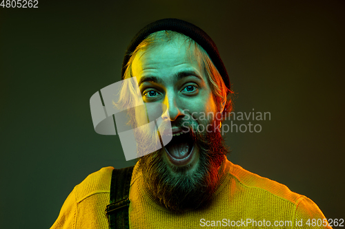 Image of Caucasian man\'s portrait isolated on gradient studio background in neon light