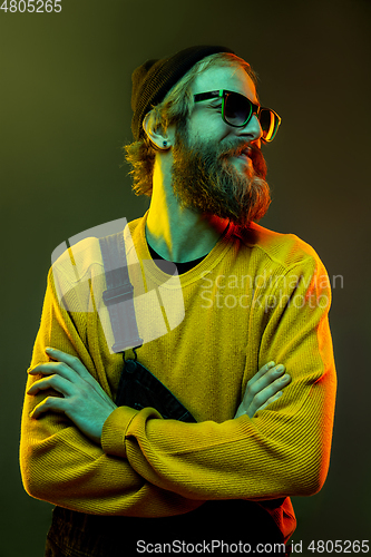 Image of Caucasian man\'s portrait isolated on gradient studio background in neon light