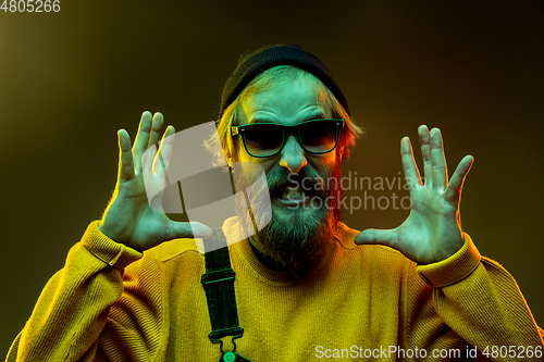 Image of Caucasian man\'s portrait isolated on gradient studio background in neon light