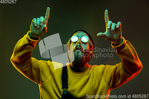 Image of Caucasian man\'s portrait isolated on gradient studio background in neon light