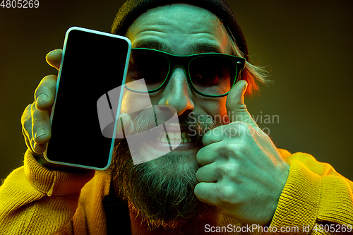 Image of Caucasian man\'s portrait isolated on gradient studio background in neon light