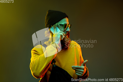 Image of Caucasian man\'s portrait isolated on gradient studio background in neon light