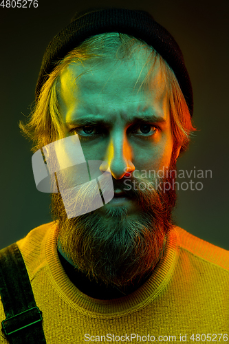 Image of Caucasian man\'s portrait isolated on gradient studio background in neon light