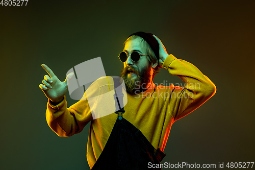 Image of Caucasian man\'s portrait isolated on gradient studio background in neon light