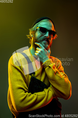 Image of Caucasian man\'s portrait isolated on gradient studio background in neon light