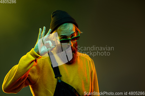 Image of Caucasian man\'s portrait isolated on gradient studio background in neon light