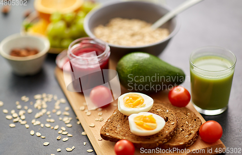 Image of toast bread, eggs, avocado, jam, tomato and juice