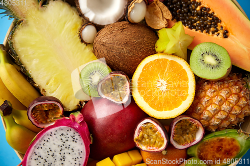 Image of different exotic fruits on blue background