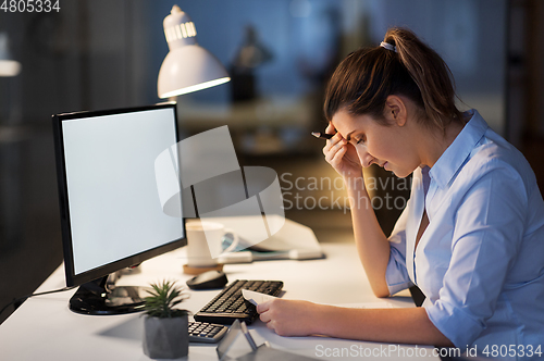 Image of businesswoman with papers working at night office