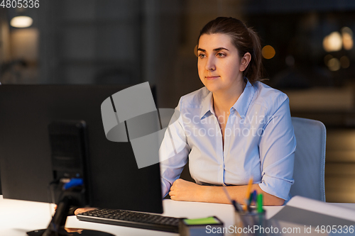 Image of businesswoman working on computer at night office