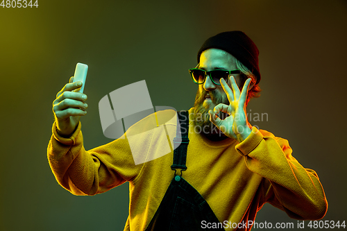 Image of Caucasian man\'s portrait isolated on gradient studio background in neon light