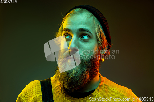 Image of Caucasian man\'s portrait isolated on gradient studio background in neon light
