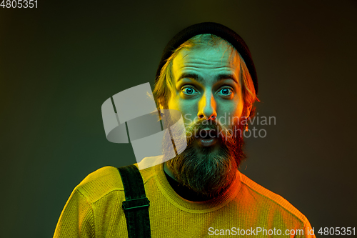 Image of Caucasian man\'s portrait isolated on gradient studio background in neon light