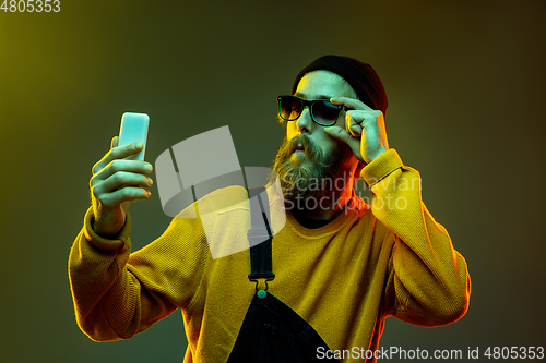 Image of Caucasian man\'s portrait isolated on gradient studio background in neon light