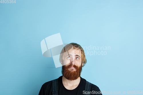 Image of Portrait of young caucasian man looks dreamful and happy