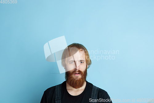Image of Portrait of young caucasian man looks dreamful and happy
