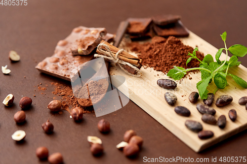 Image of chocolate with nuts, cocoa beans and cinnamon