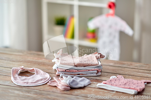 Image of baby clothes on wooden table at home