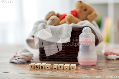 Image of teddy bear toy in basket with baby things on table