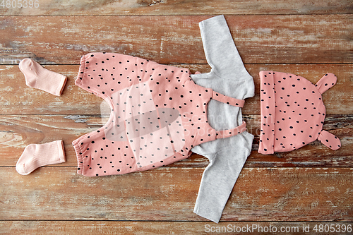 Image of baby clothes set on wooden table