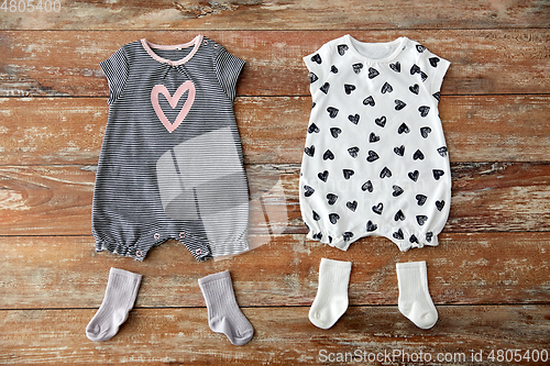 Image of baby bodysuits and socks on wooden table