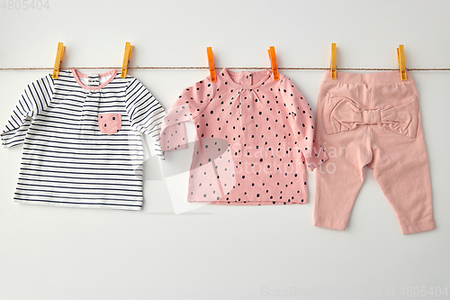 Image of shirts and pants for baby girl on clothesline