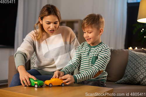 Image of mother and son playing with toy cars at home