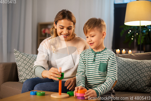 Image of mother and son playing with toy pyramid at home