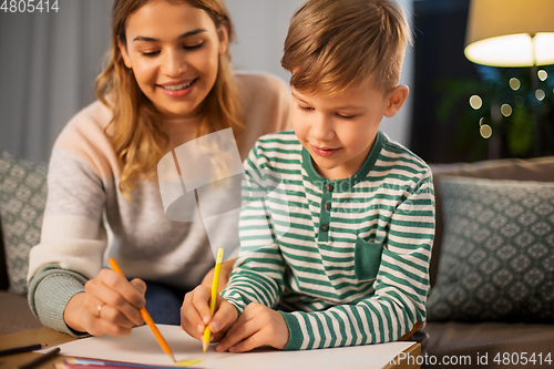 Image of mother and son with pencils drawing at home