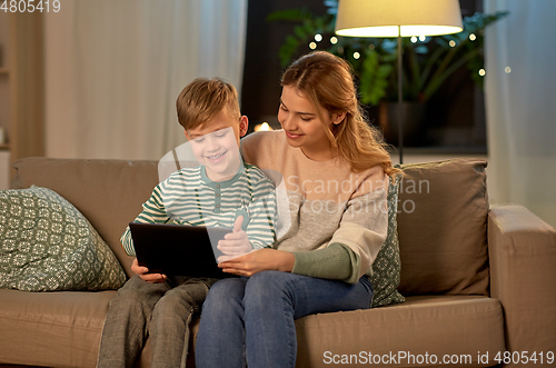 Image of mother and son using tablet computer at home