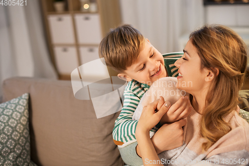 Image of happy smiling mother and son hugging at home