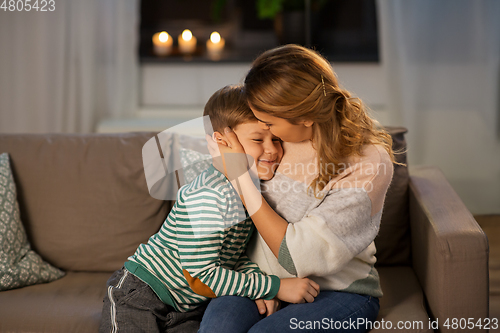 Image of happy smiling mother and son hugging at home