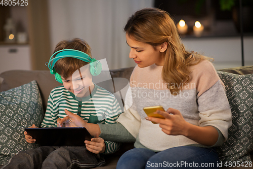 Image of mother and son using gadgets at home