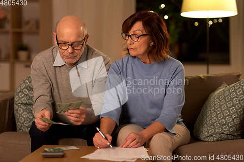 Image of senior couple with bills counting money at home