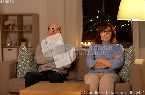 Image of unhappy senior couple sitting on sofa at home