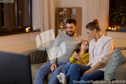 Image of happy family watching tv at home at night